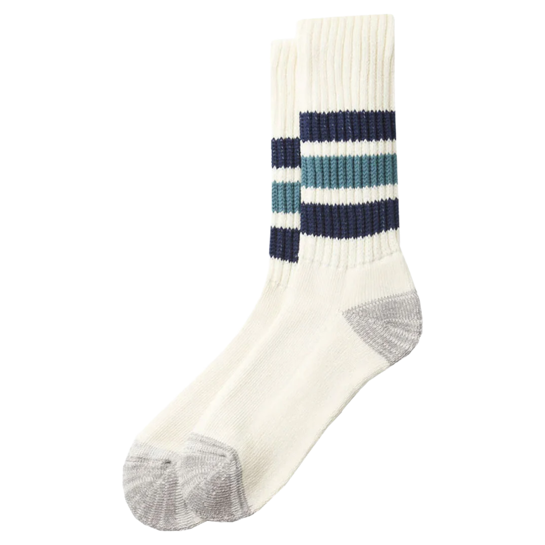 A pair of cream-colored crew socks with gray heels and toes, featuring navy and teal horizontal stripes around the upper calf.
