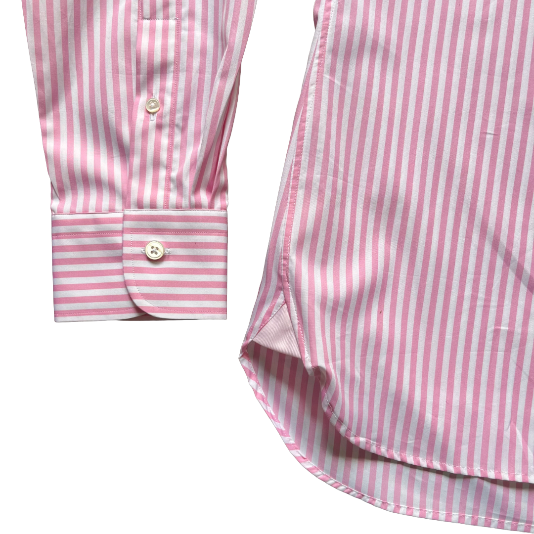 Pink and white striped long-sleeve shirt shown in a close-up detail shot, featuring the buttoned cuff and part of the curved hem on a white background.
