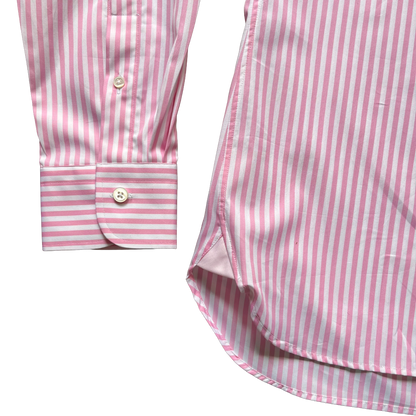 Pink and white striped long-sleeve shirt shown in a close-up detail shot, featuring the buttoned cuff and part of the curved hem on a white background.