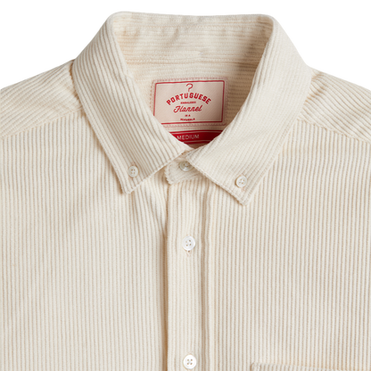 Close-up of a cream-colored Portugueseannel button-down shirt with a ribbed corduroy-like texture, featuring a pointed collar and white buttons.
