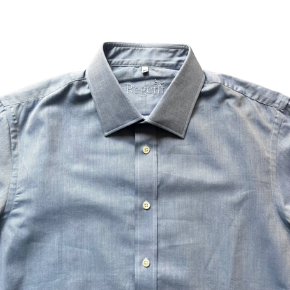 A close-up of a light blue chambray button-down shirt with a spread collar, showing the 'Regeffi' brand name embroidered inside the collar, set against a plain white background.