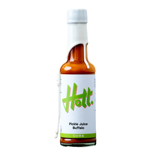 A bottle of Hott. Pickle Juice Buffalo hot sauce with a white label featuring green logo text, set against a plain white background.