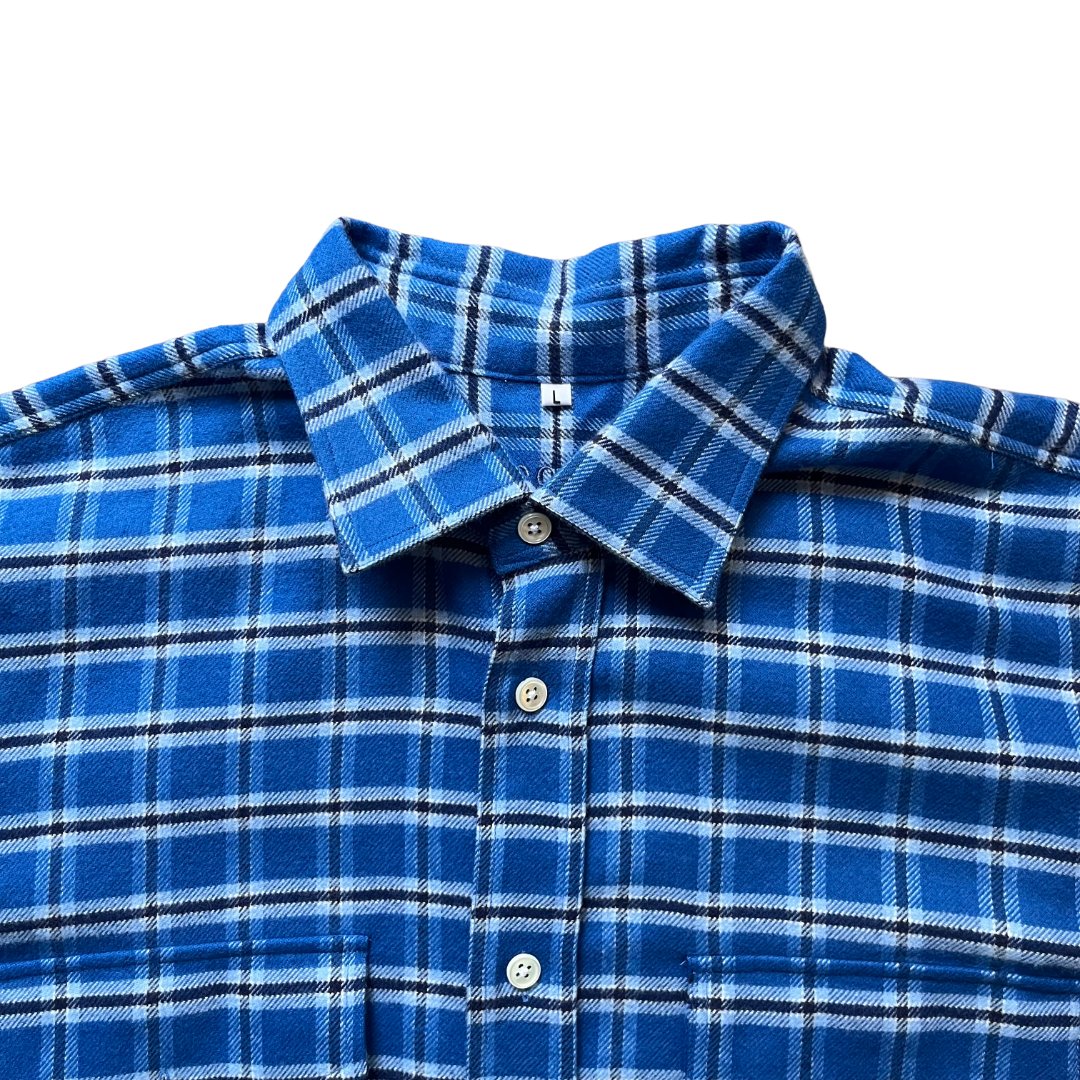 Close-up of a blue plaid button-up shirt collar and upper front with white buttons