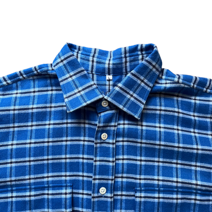 Close-up of a blue plaid button-up shirt collar and upper front with white buttons