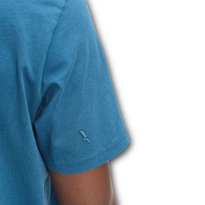 Close-up of the sleeve of a blue Aigle t-shirt with a small logo on a white background sold at Regent in Salisbury