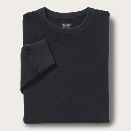 Folded black sweater with Filson logo on a light gray background