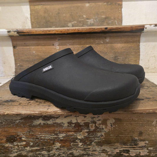 Black clogs on a wooden surface with a rustic background