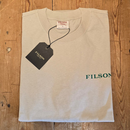 Beige t-shirt with 'Filson' branding on a wooden surface
