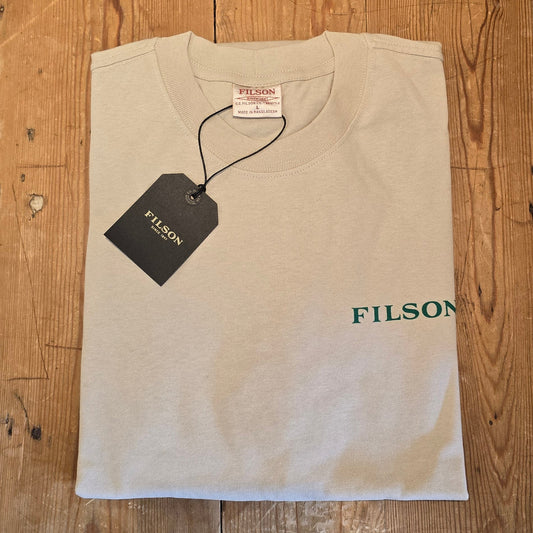 Beige t-shirt with 'Filson' branding on a wooden surface