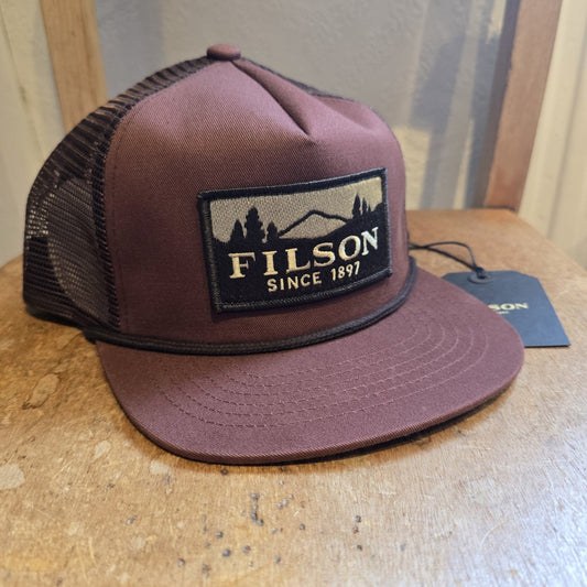 Brown Filson cap on a wooden surface with a blurred background