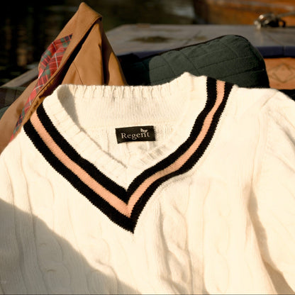 White sweater with black and pink trim on a hanger