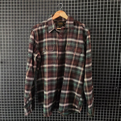 Plaid shirt hanging on a grid wall with bags and shoes around
