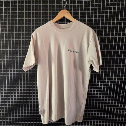 Beige t-shirt with 'Fusion' logo on a hanger against a grid wall.