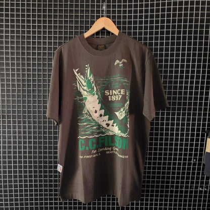 Charcoal t-shirt with graphic design on a hanger against a grid wall