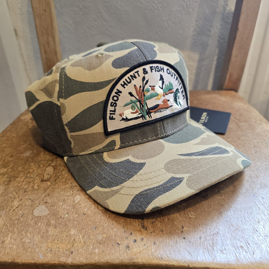 Camouflage cap with a patch on a wooden surface