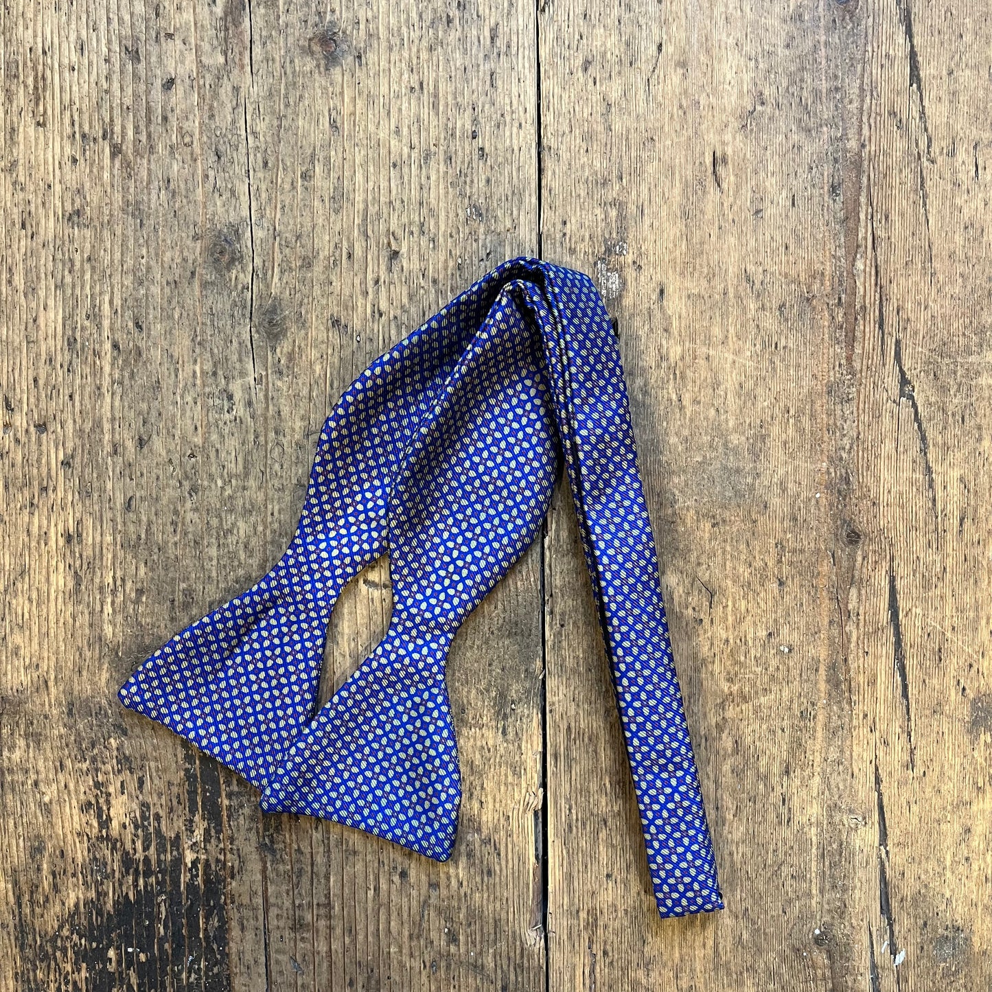 Blue bow tie with Geometric Floral Pattern, in yellow, blue and maroon.
Sold at Regent Tailoring Salisbury