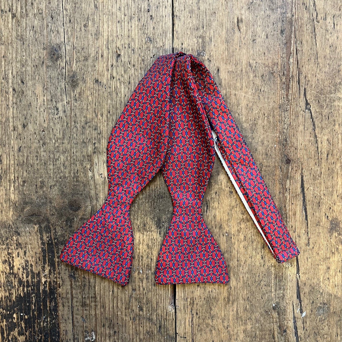 Red and blue patterned bow tie, sea style nott, pattern - available at Regent Tailoring in Salisbury 