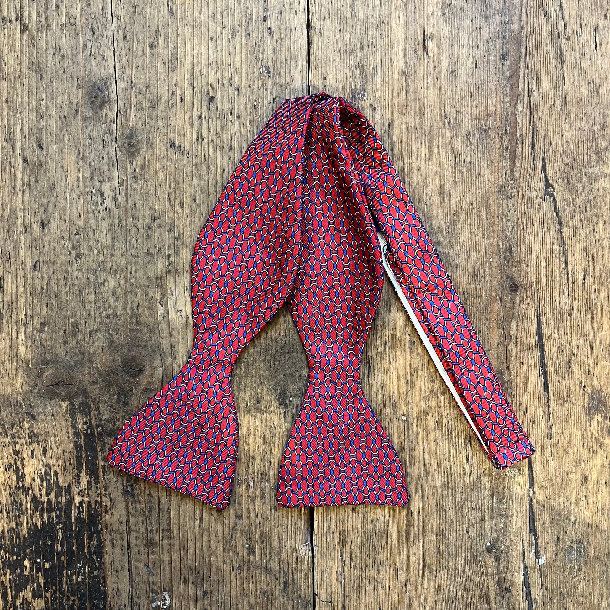 Red and blue patterned bow tie, sea style nott, pattern - available at Regent Tailoring in Salisbury 
