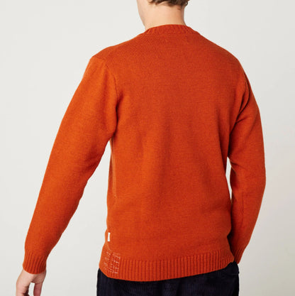 Orange sweater worn by a person on a white background