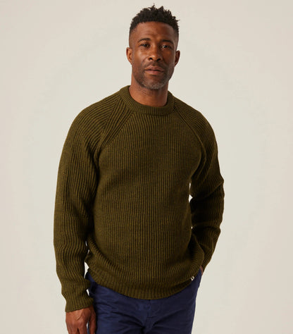 Man wearing a green sweater against a plain background