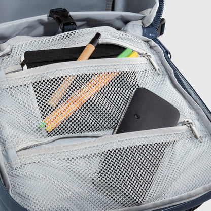 Gray backpack with a mesh pocket containing stationery items on a light gray background