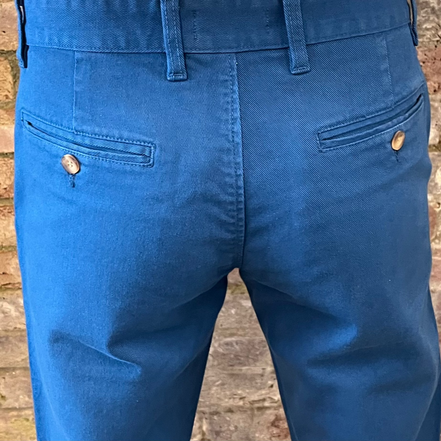 The back pockets of blue chinos