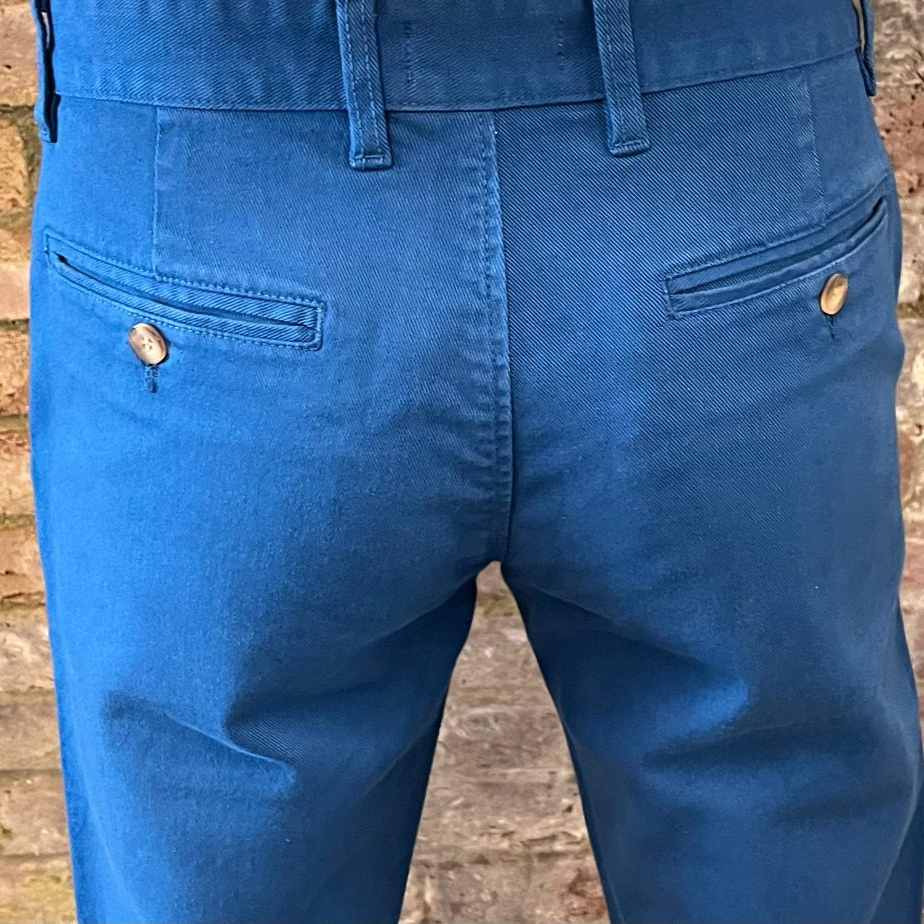 The back pockets of blue chinos