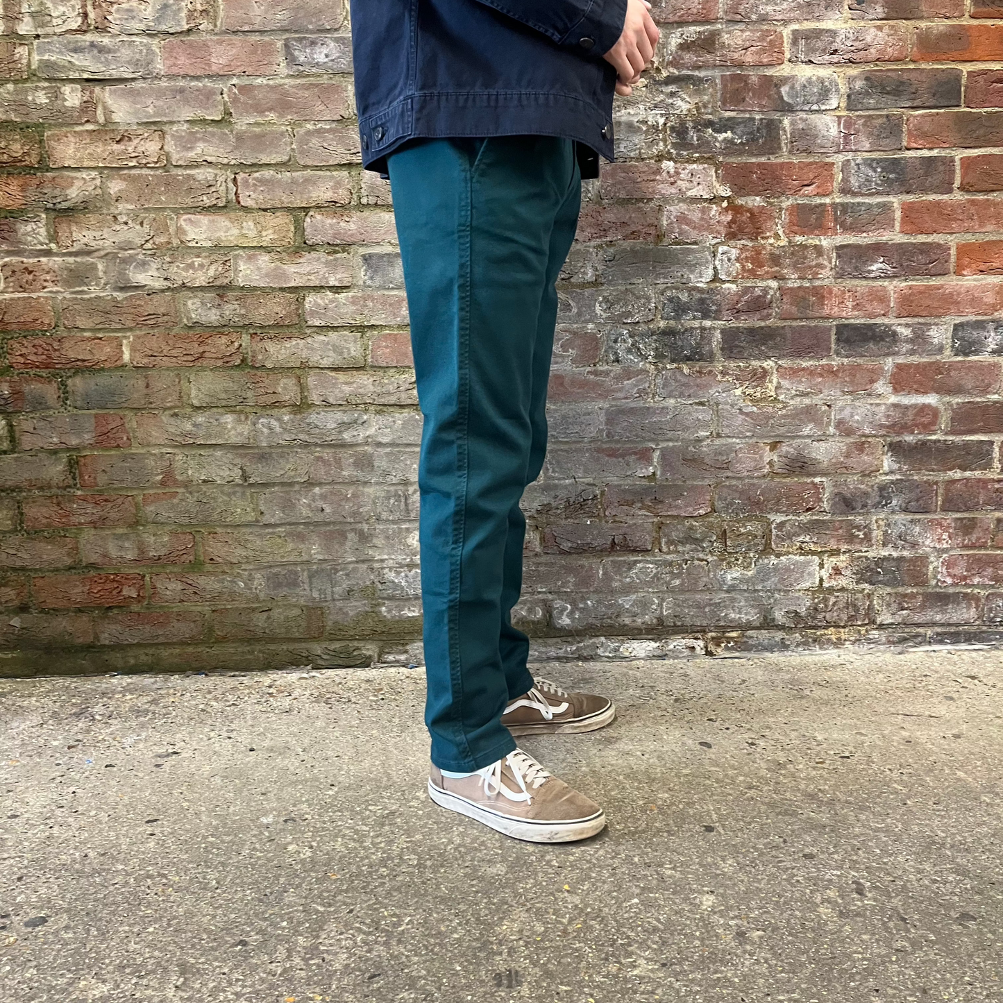 A person wears green chinos