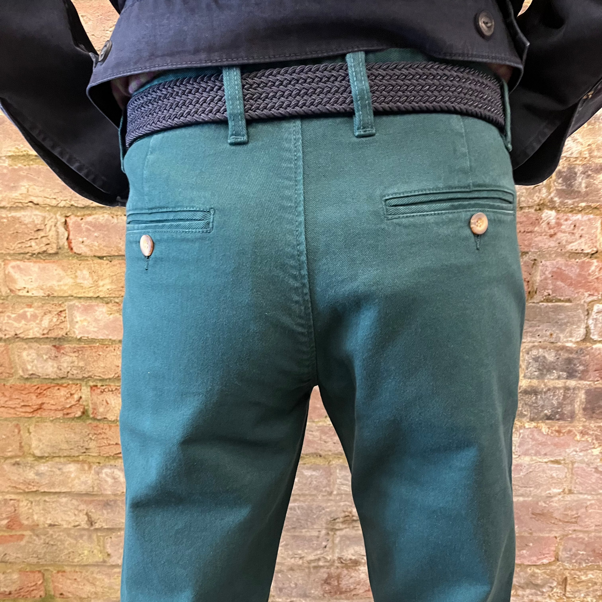 A person wears green chinos