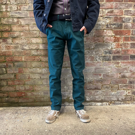 A person wears green chinos