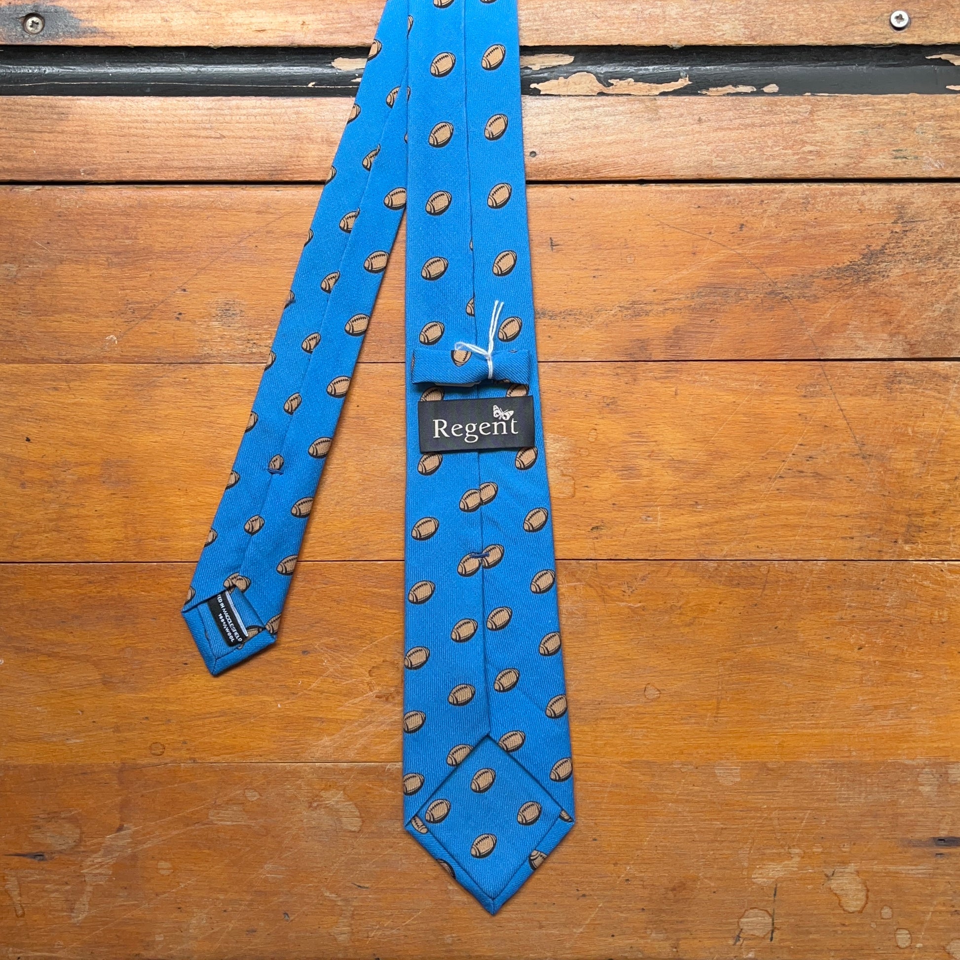 Blue regent tie made from woven wool with rugby ball print pattern - reverse