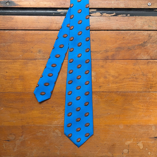 Blue regent tie made from woven silk with rugby ball print pattern