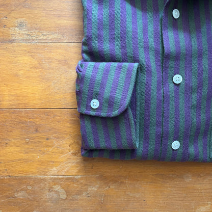 Single-button rounded cuff of a purple and green striped cotton flannel shirt