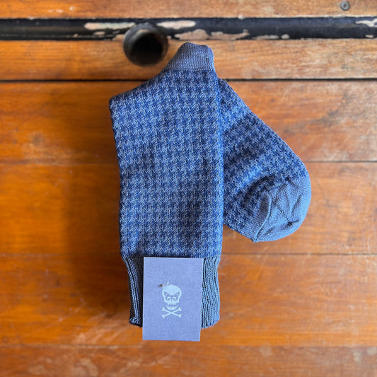 Blue socks with a dogtooth pattern on a wooden backdrop