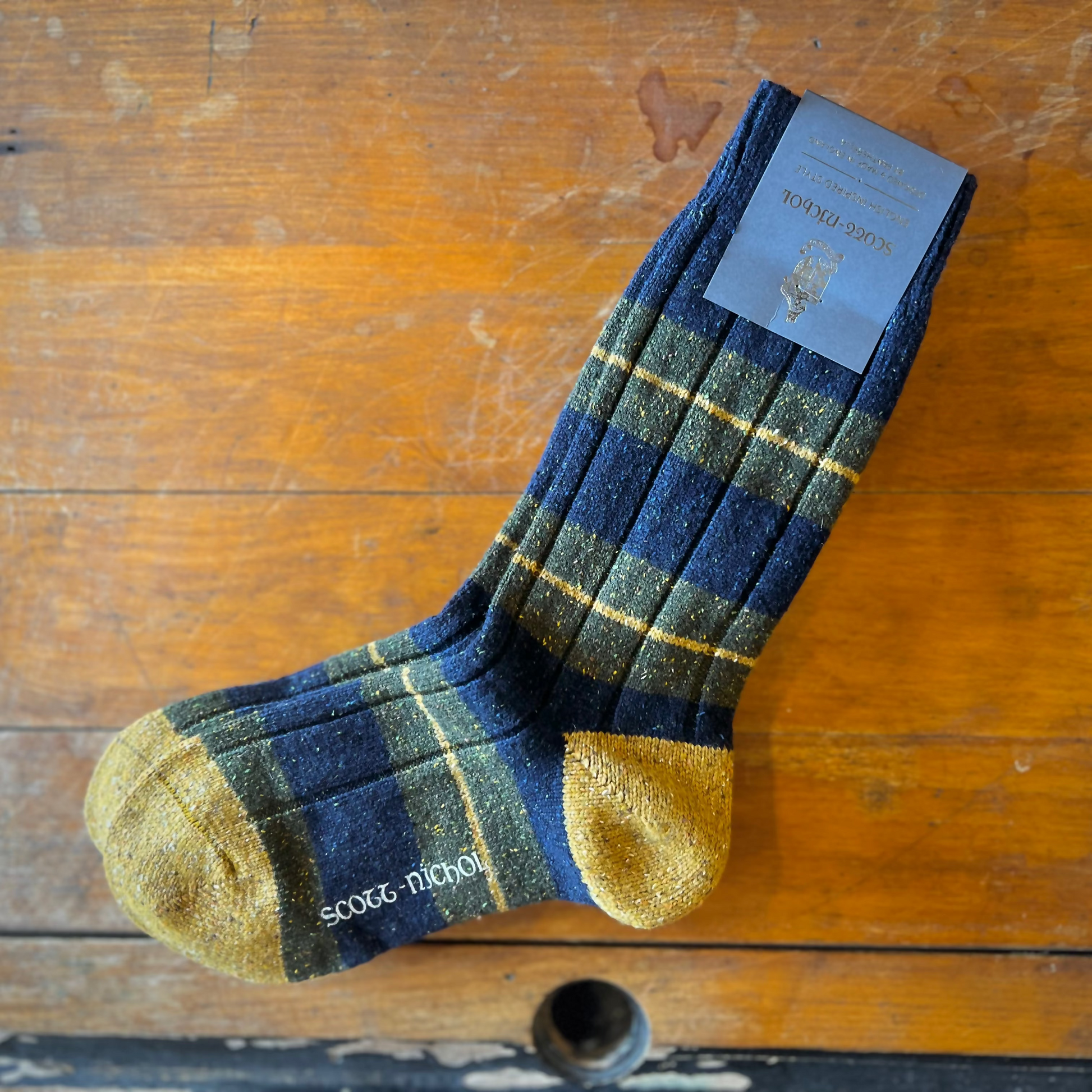 Scott-Nichol socks on a wooden backdrop