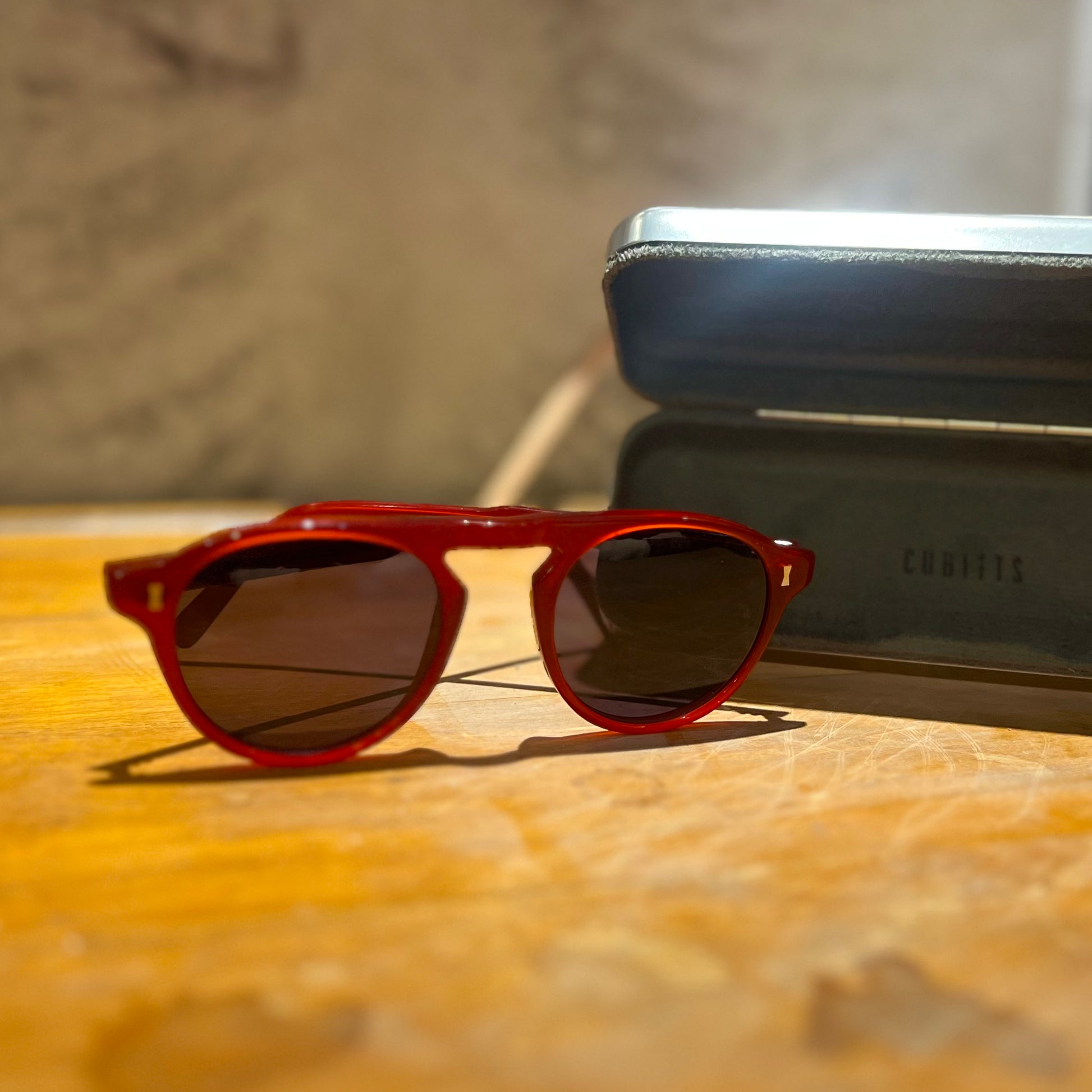 Red sunglasses on a wooden table