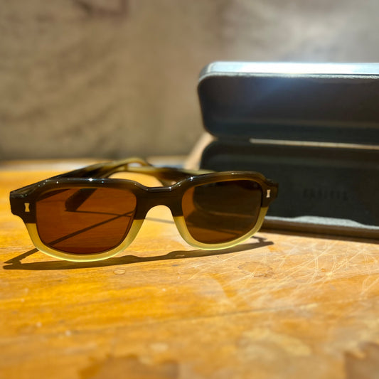 Beechwood sunglasses with a cream base on a wooden desk