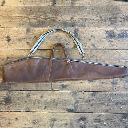 Leather rifle case on a wooden floor