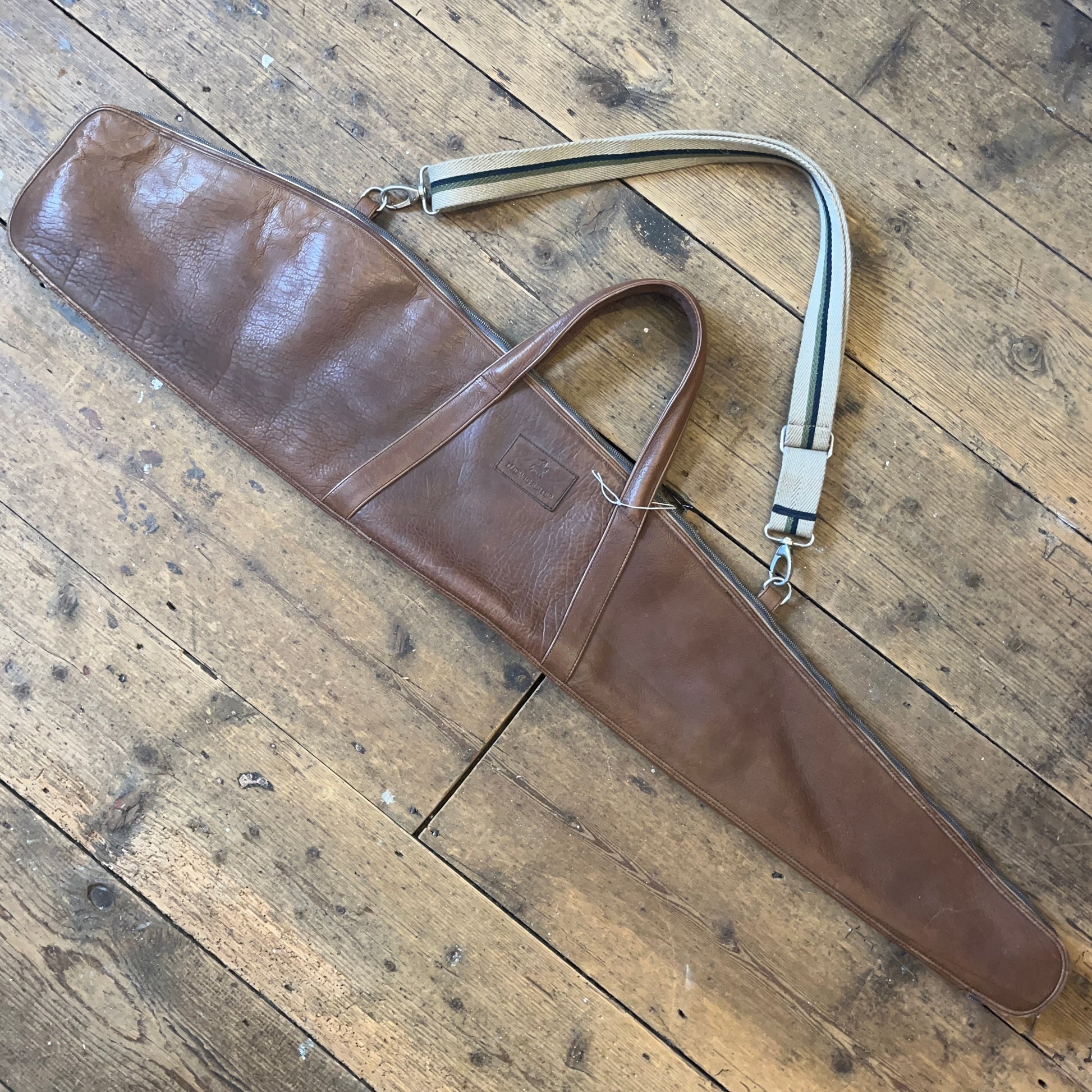 Leather rifle case on a wooden floor