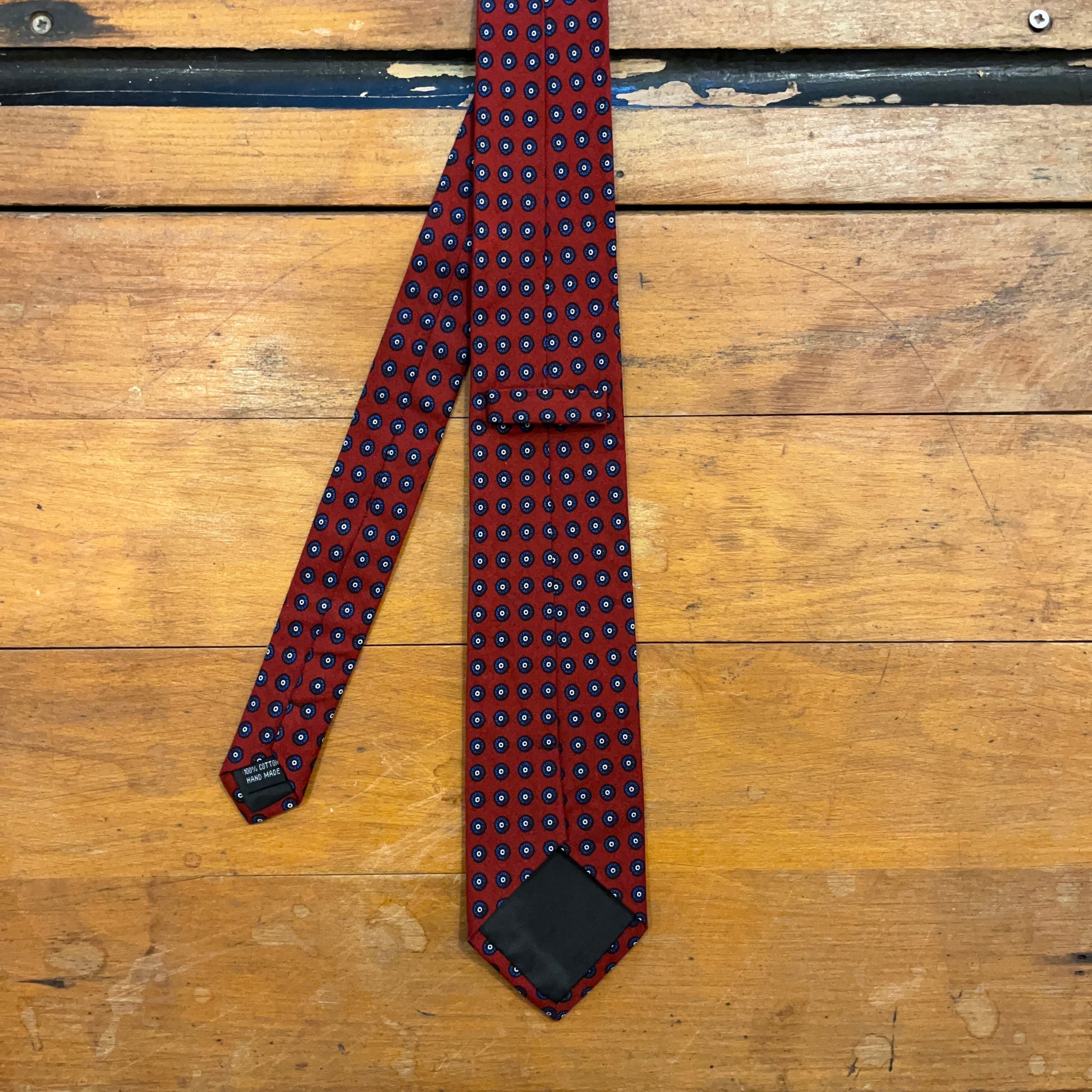 Burgundy cotton tie with blue mandala pattern on boards