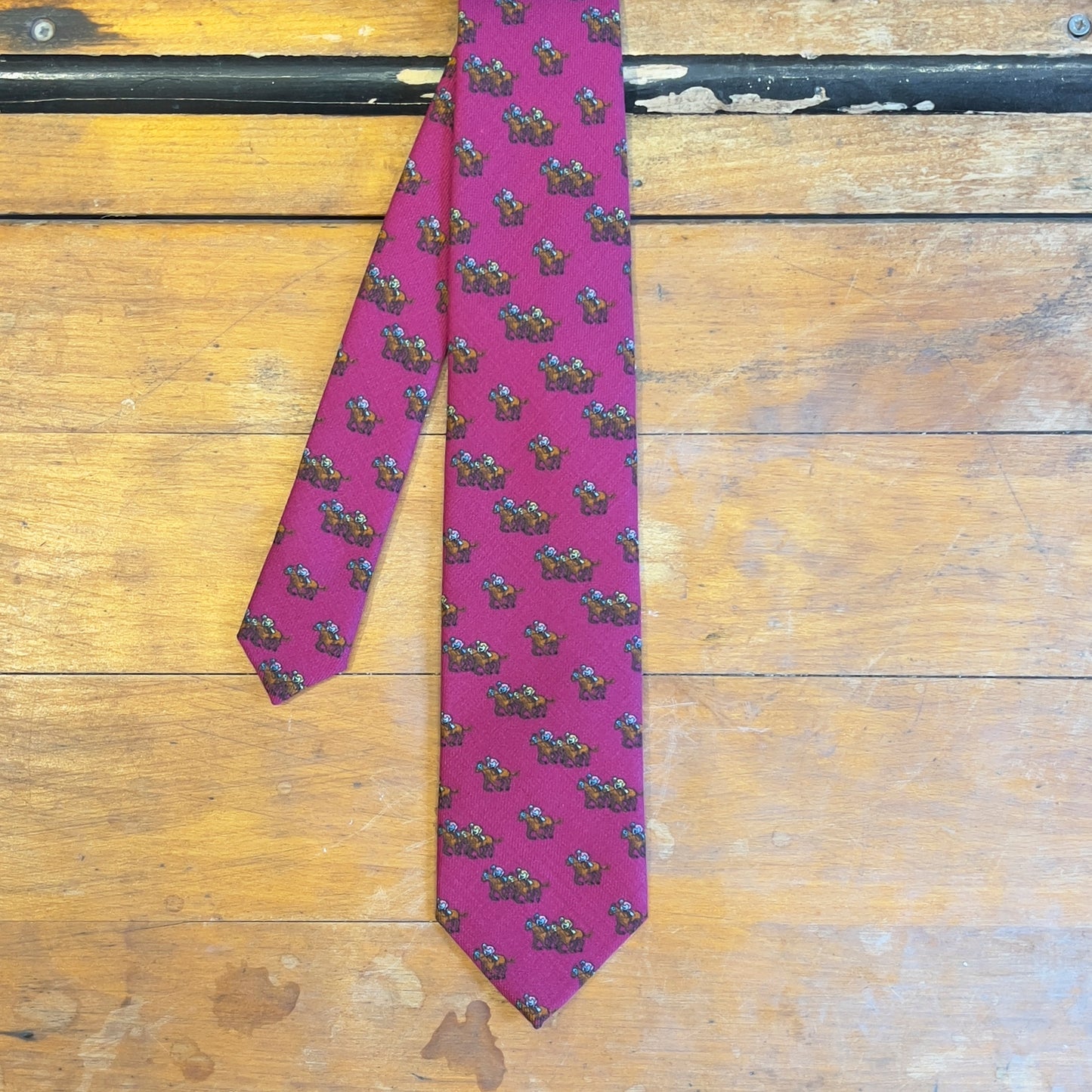 A pink tie with jockeys riding horses