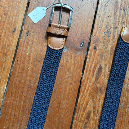 Blue woven belt with brown leather buckle on a wooden surface