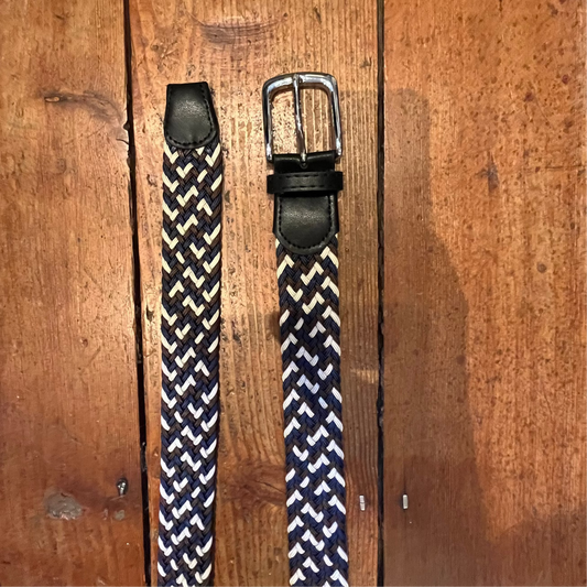 Two woven belts with different buckles on a wooden surface