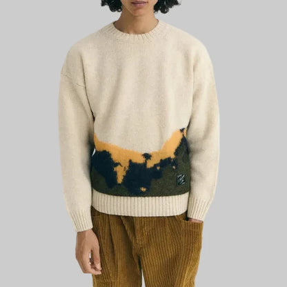 Person wearing a beige sweater with a colorful design on a white background