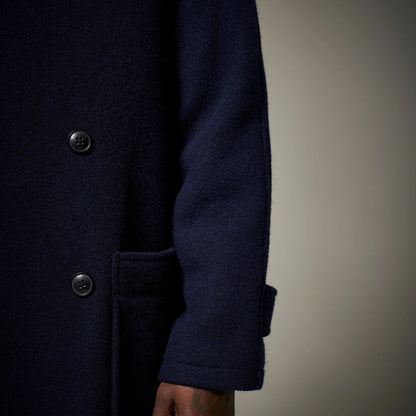 Navy blue coat with button details on a neutral background