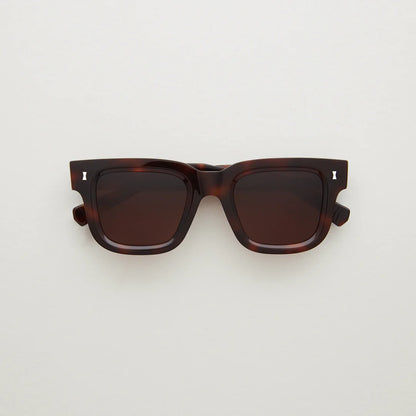 Dark tortoiseshell acetate sunglasses, silver detail in far corner, large rectangular shape. 