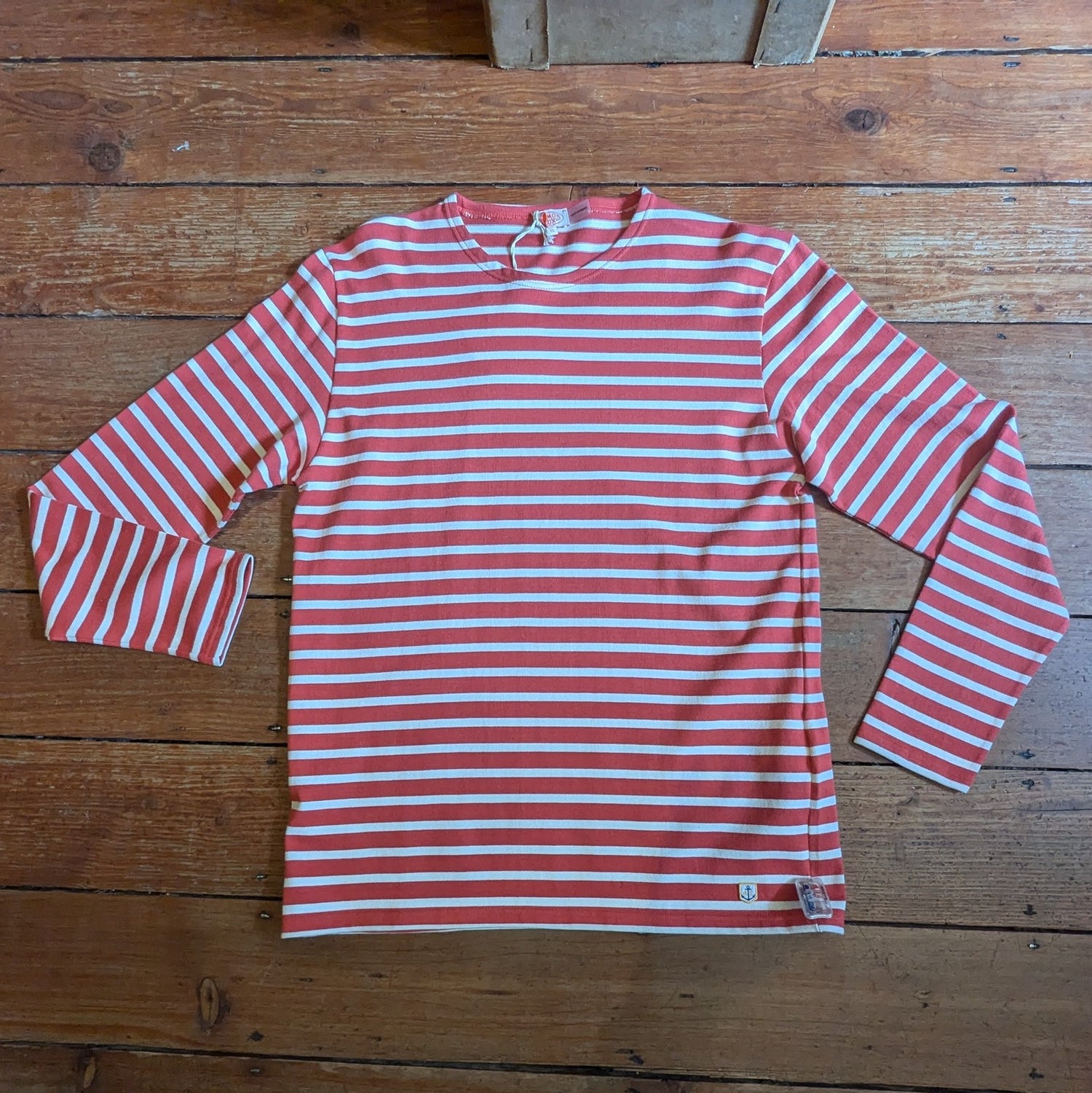 Red/White breton top with logo ion bottom left.