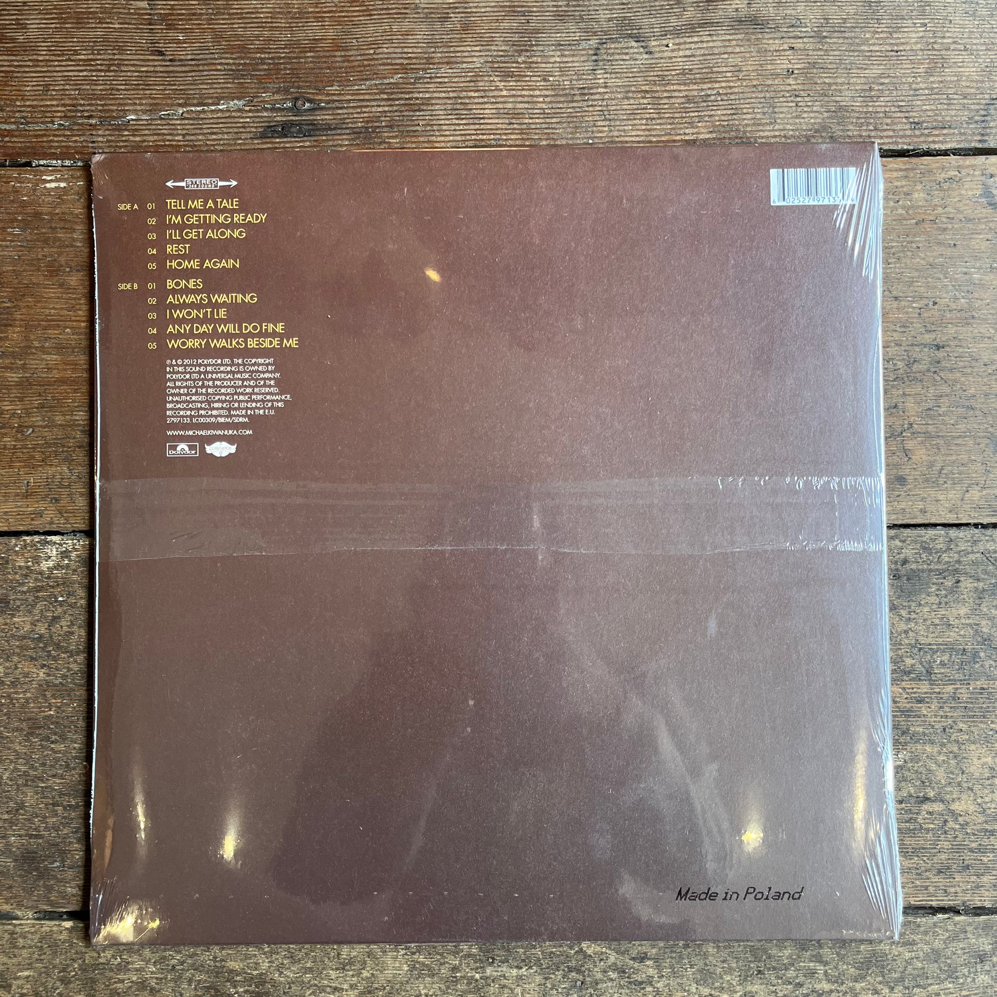 Vinyl record cover with text on a wooden surface