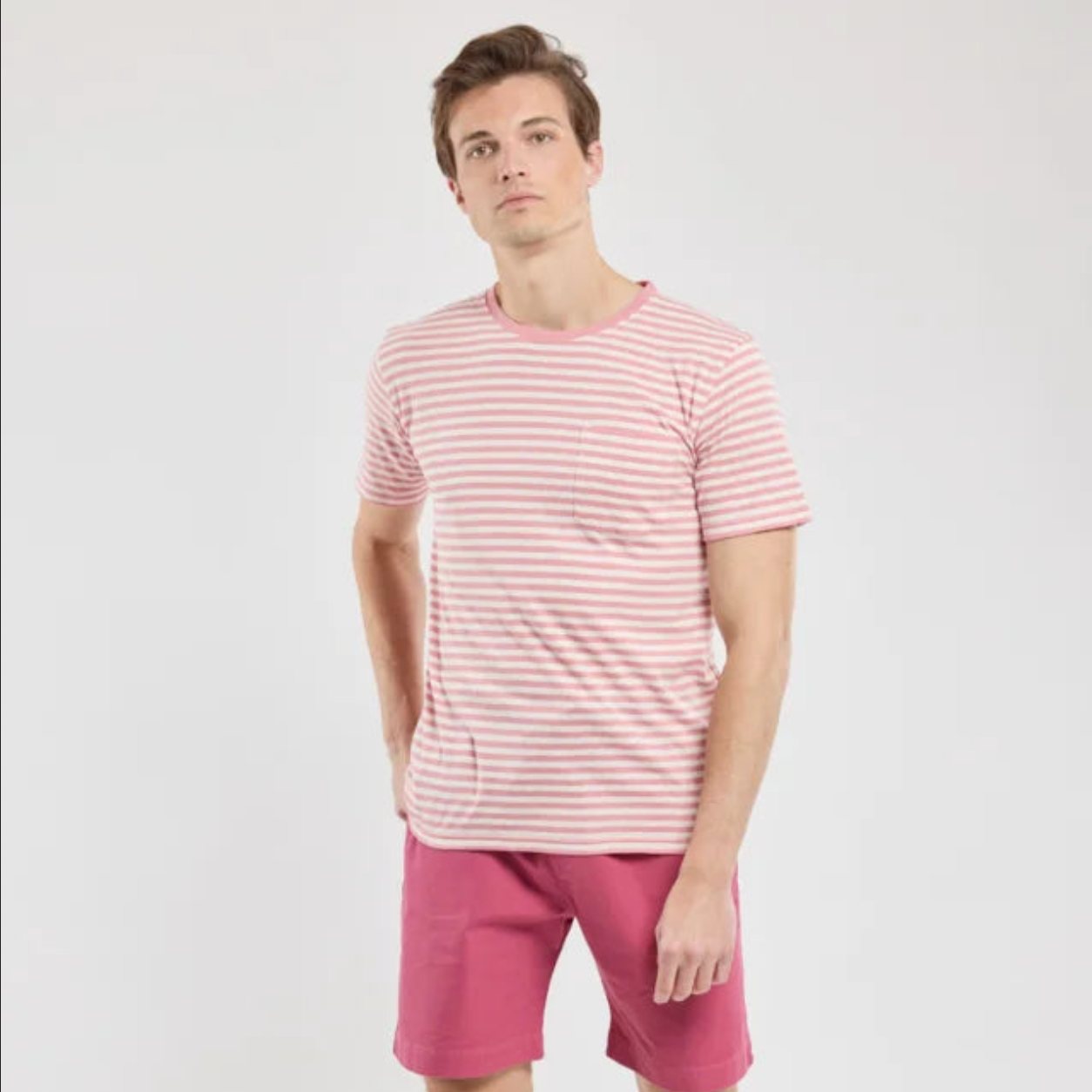 A man wears a pink t-shirt