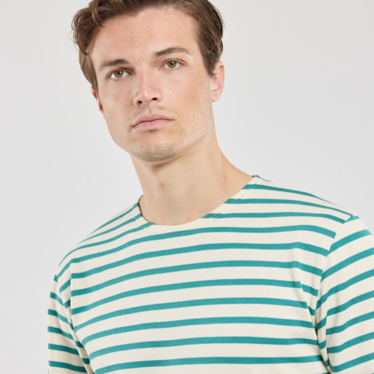 A man wearing a green striped long sleeve shirt